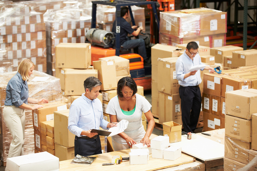 Male And Female Workers In Warehouse Preparing Goods For Dispatch